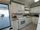 Functional kitchen with white appliances, cabinetry, and access to the screened pool area at 1130 N Mill Ave, Bartow, FL 33830