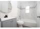 Bathroom with white tiling, gray vanity, and shower-tub combo at 1328 3Rd Ne St, Winter Haven, FL 33881