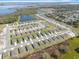 An aerial view of a new community with modern homes, green spaces, and a scenic lake in the distance at 1340 Oak Valley Drive, Auburndale, FL 33823