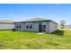 A gray single-story home featuring a well-maintained lawn and a sliding glass door leading to the backyard at 1340 Oak Valley Drive, Auburndale, FL 33823