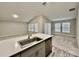 Open kitchen with an island featuring a sink, gray cabinets, and view to the living area at 1397 Axel Cir, Winter Haven, FL 33880