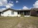 Home's back exterior featuring a screened in patio and outdoor space at 1411 Grand Cayman Cir, Winter Haven, FL 33884