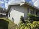 The side of the house is landscaped with green bushes and small plants at 1411 Grand Cayman Cir, Winter Haven, FL 33884