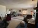 Spacious living room featuring carpeted floors, two recliners, a drum set and windows with curtains at 1411 Grand Cayman Cir, Winter Haven, FL 33884