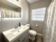 Bathroom features a vanity, stylish faucet, mirror, and shower with patterned shower curtain at 1442 Gilmore Ave, Lakeland, FL 33805
