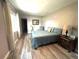 Bright bedroom showcasing wood floors, a queen bed, and neutral decor at 1442 Gilmore Ave, Lakeland, FL 33805