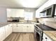 Well-lit kitchen features granite countertops, stainless steel appliances and white cabinetry at 1442 Gilmore Ave, Lakeland, FL 33805