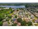 Beautiful aerial view of a home nestled among mature trees with a lake nearby in a quiet neighborhood at 1447 Kingfish Ln, Winter Haven, FL 33884