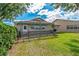Grassy backyard with a fenced patio area, pergola, and well-maintained lawn at 1447 Kingfish Ln, Winter Haven, FL 33884