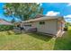 Side view of a home featuring a backyard with a pergola, grill, and lush lawn at 1447 Kingfish Ln, Winter Haven, FL 33884