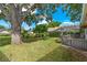 The backyard features mature trees, a patio with pergola, and well-maintained lawn at 1447 Kingfish Ln, Winter Haven, FL 33884