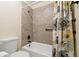 A clean bathroom showcases a shower and tub combination with sleek tile, accented by floral curtain design at 1447 Kingfish Ln, Winter Haven, FL 33884