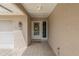 Inviting covered entryway features a tiled floor, textured walls, and decorative floral wreath on the front door at 1447 Kingfish Ln, Winter Haven, FL 33884
