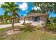 Well-maintained home with lush landscaping, a mature palm tree, and a paved driveway at 1447 Kingfish Ln, Winter Haven, FL 33884