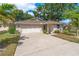 Charming one-story home with a well-manicured lawn, mature trees, and an attached two-car garage at 1447 Kingfish Ln, Winter Haven, FL 33884