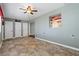 Living room with neutral walls, tile floor, ceiling fan, and access to two closets and an adjacent room at 1447 Kingfish Ln, Winter Haven, FL 33884
