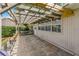 Covered outdoor patio area with a pergola, brick floor, privacy fence, and access to the home's interior at 1447 Kingfish Ln, Winter Haven, FL 33884