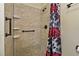Close-up of the tiled shower with built-in shelves and floral shower curtain at 1447 Kingfish Ln, Winter Haven, FL 33884