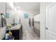 Bathroom featuring double sinks, a large mirror, and a shower-tub combo with a curtain at 148 Emanuelle Dr, Winter Haven, FL 33884