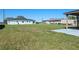 Large backyard with green grass, a covered structure, and neighboring houses at 1530 S Lake Howard Dr, Winter Haven, FL 33880