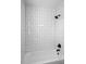 Modern bathtub with white subway tile surround and dark fixtures at 1530 S Lake Howard Dr, Winter Haven, FL 33880