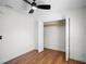 Bright bedroom features hardwood floors, a ceiling fan, and a closet for storage convenience at 1530 S Lake Howard Dr, Winter Haven, FL 33880