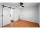 Bedroom featuring hardwood floors, ceiling fan, and sliding door leading to bathroom at 1530 S Lake Howard Dr, Winter Haven, FL 33880