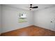 Empty bedroom with hardwood floors, ceiling fan, and bright window with a view at 1530 S Lake Howard Dr, Winter Haven, FL 33880