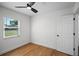 Bright bedroom features hardwood floors, a ceiling fan, and a window for natural light and views at 1530 S Lake Howard Dr, Winter Haven, FL 33880