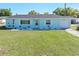 Charming light blue single-story home with a well-maintained lawn and tidy, decorative landscaping at 1530 S Lake Howard Dr, Winter Haven, FL 33880