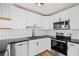 Modern kitchen featuring stainless steel appliances, white cabinets, and sleek black countertops at 1530 S Lake Howard Dr, Winter Haven, FL 33880