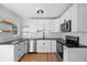 Modern kitchen featuring stainless steel appliances, black countertops, white cabinets, and open shelving at 1530 S Lake Howard Dr, Winter Haven, FL 33880