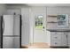 Bright kitchen featuring stainless steel refrigerator, backyard access door, and butcher block shelves at 1530 S Lake Howard Dr, Winter Haven, FL 33880