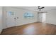 Bright living room with new light wood flooring, barn door, ceiling fan, and large window at 1530 S Lake Howard Dr, Winter Haven, FL 33880