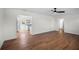 Open-concept living room with wood floors, white trim and glimpses of a modern, bright kitchen at 1530 S Lake Howard Dr, Winter Haven, FL 33880