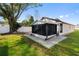 Exterior view of backyard featuring screened-in porch and well-maintained lawn at 1822 Nicaragua Way, Winter Haven, FL 33881