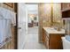 Neutral half bathroom featuring a wood vanity, decorative wallpaper, and white tile flooring at 1822 Nicaragua Way, Winter Haven, FL 33881