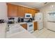 Well-lit kitchen with white appliances, oak cabinets, and tile flooring at 1822 Nicaragua Way, Winter Haven, FL 33881