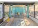 Bright sunroom with large windows, striped sofa, and decoratively colored accents at 1822 Nicaragua Way, Winter Haven, FL 33881