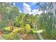 Lush backyard featuring mature landscaping, a pond view, and a stone walkway at 200 El Camino Dr # 206, Winter Haven, FL 33884