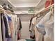 Organized walk-in closet with hanging clothes and bags on shelves at 200 El Camino Dr # 206, Winter Haven, FL 33884