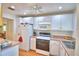 Efficient kitchen with white cabinets, essential appliances, and a ceiling fan ensuring a comfortable cooking experience at 200 El Camino Dr # 206, Winter Haven, FL 33884