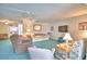 Spacious living room with comfortable seating, blue carpet, ceiling fans, and a wall-mounted TV at 200 El Camino Dr # 206, Winter Haven, FL 33884