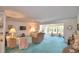 Cozy living room with large windows, comfortable seating, ceiling fan, and light blue carpeting at 200 El Camino Dr # 206, Winter Haven, FL 33884