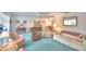 Spacious living room with sofa, love seat, recliner, blue carpet, and views through large windows at 200 El Camino Dr # 206, Winter Haven, FL 33884