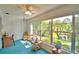 Sunroom with large windows offering scenic views of the outside landscape, with blue rug and furnishings at 200 El Camino Dr # 206, Winter Haven, FL 33884