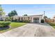 Cozy brick home with an attached garage, long driveway, and tidy landscaping under a clear sky at 205 Kilmer Ln, Winter Haven, FL 33884