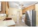 Spacious kitchen features ample wood cabinetry, speckled floors, and modern stainless steel refrigerator at 205 Kilmer Ln, Winter Haven, FL 33884
