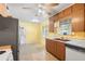 Sunny kitchen with wood cabinets, speckled flooring, and a view of the backyard through the window at 205 Kilmer Ln, Winter Haven, FL 33884