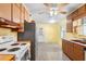 Bright kitchen featuring wood cabinets, white appliances, and a retro feel with speckled flooring at 205 Kilmer Ln, Winter Haven, FL 33884